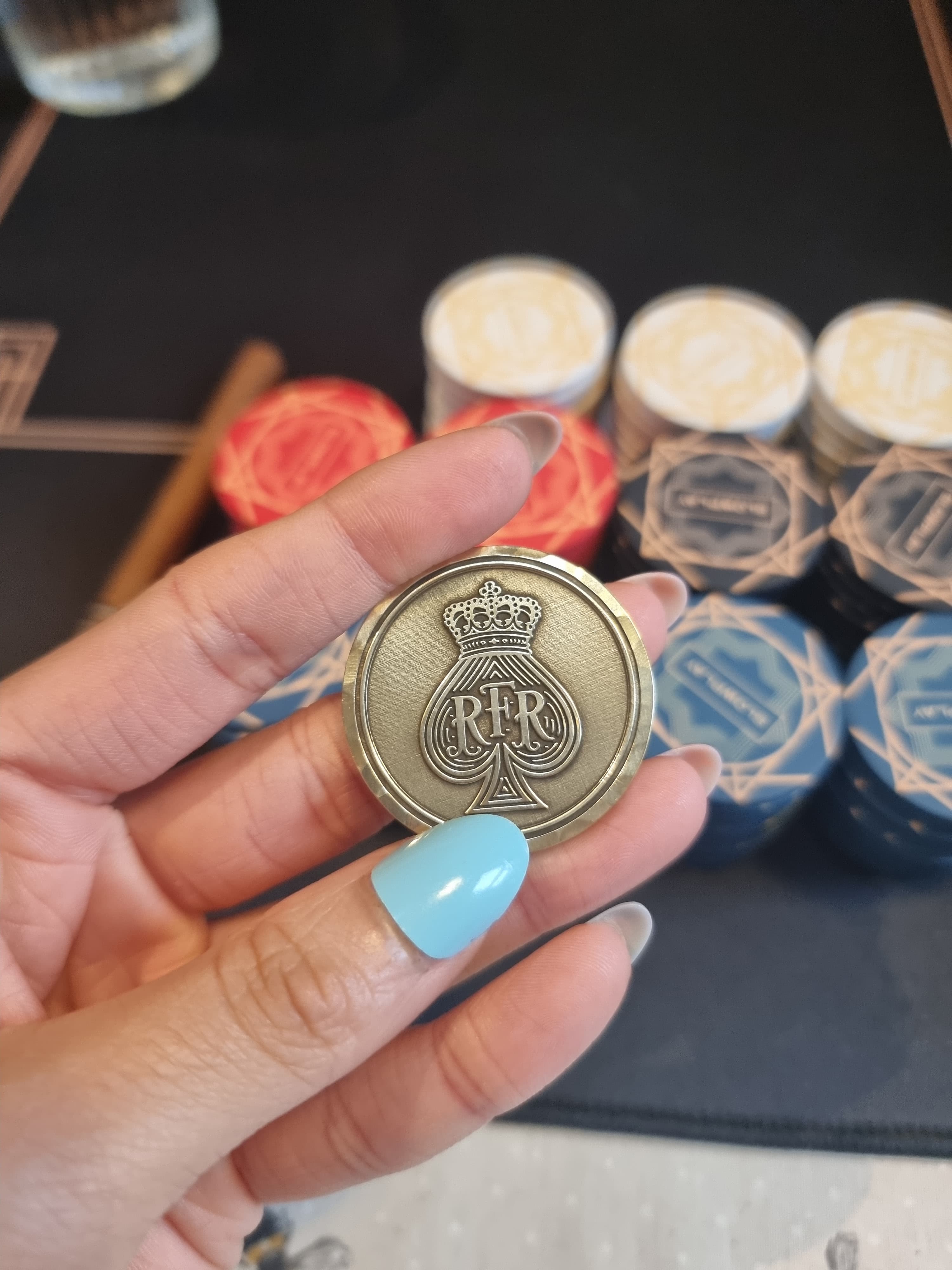A personal metal coin embossed with the crowned RFR crest