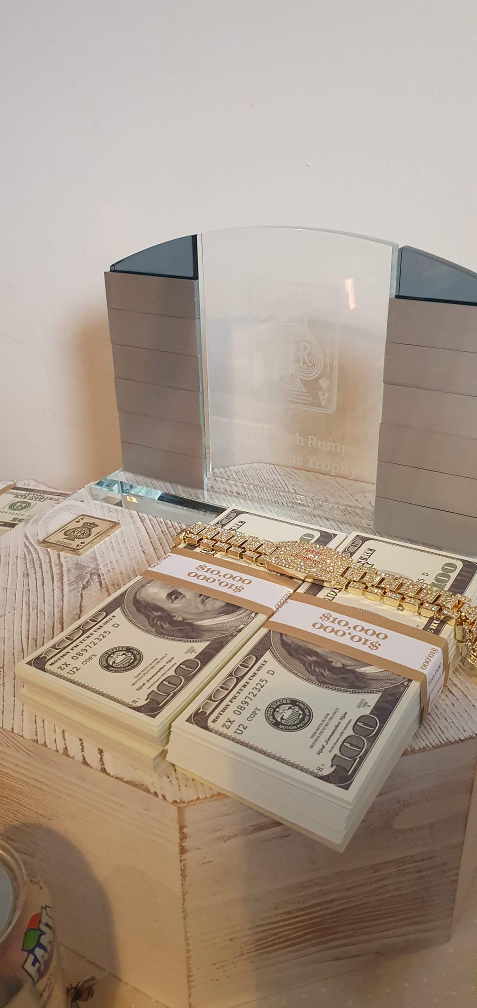 Stacks of novelty cash, a winner's bracelet and a miniature metal card beside the original RFR trophy