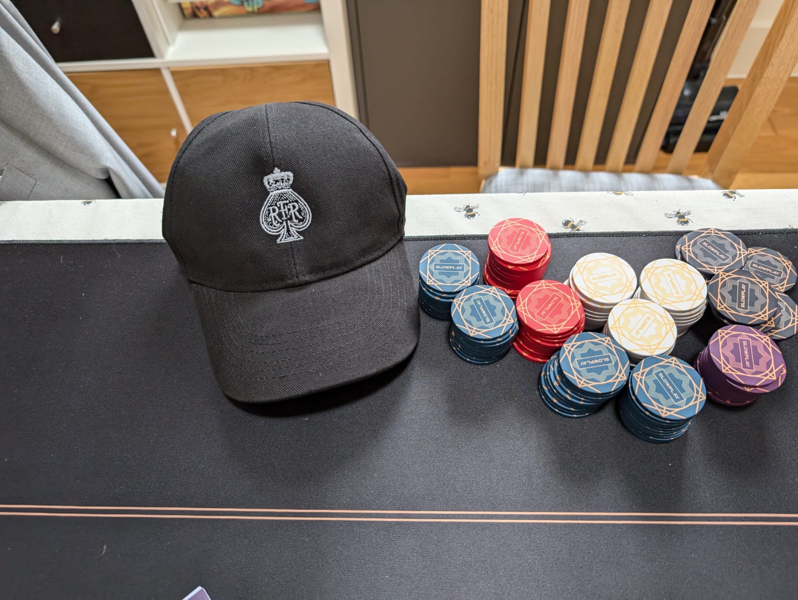 An embroidered black RFR cap beside stacks of poker chips